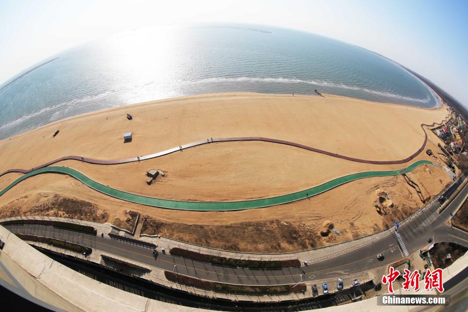 3月13日，秦皇島萬米臨海沙灘木棧道。據(jù)了解，該木棧道全長約4200米，與北戴河區(qū)原有的7500米木棧道對接后全線總長度1.17萬米，整個木棧道東起秦皇島體育基地游船碼頭，西至北戴河濕地公園，呈波浪形蜿蜒10.4公里海岸線。 中新社發(fā) 曹建雄 攝 CNSPHOTO